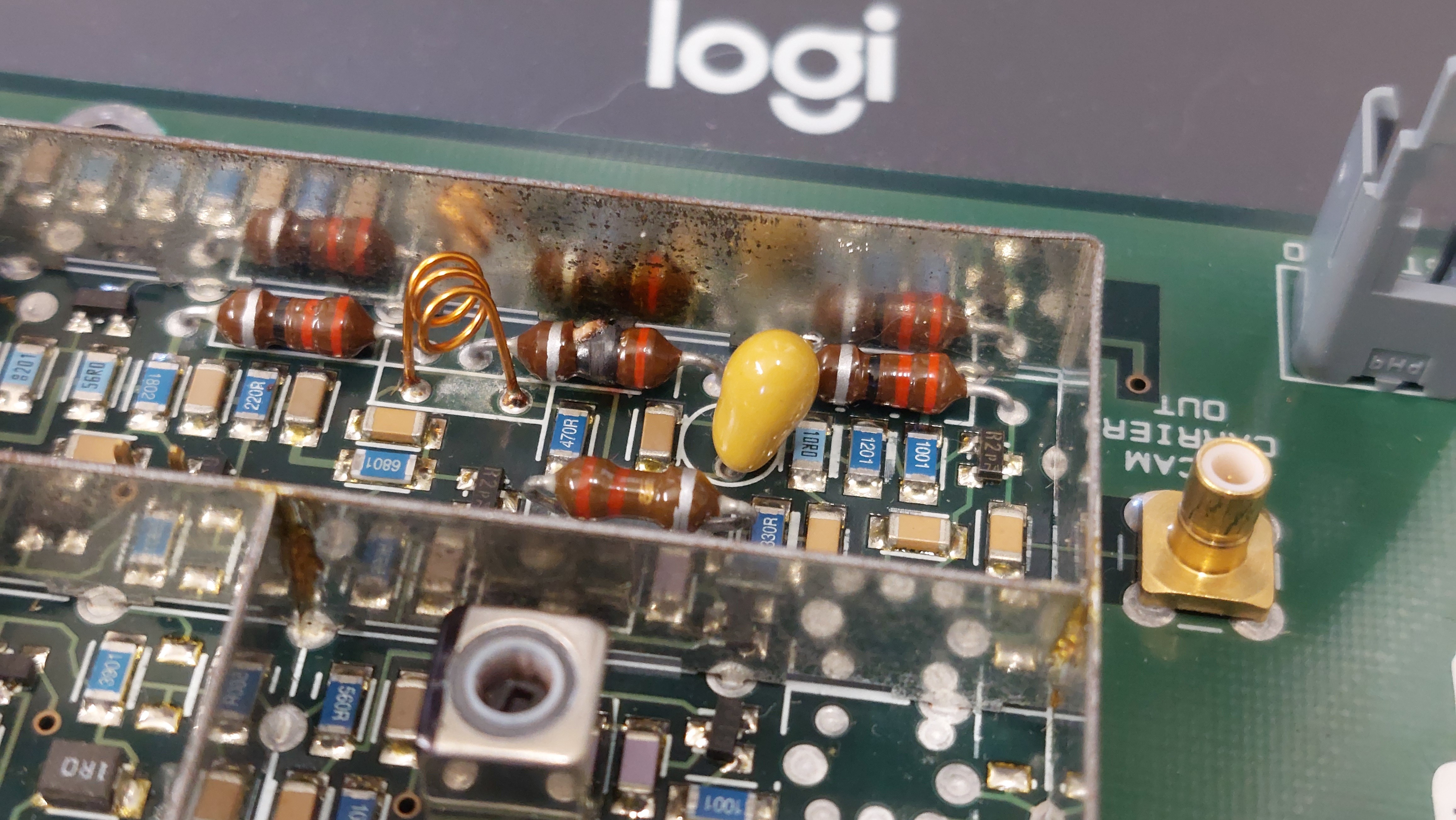 Close-up photo of the PCB with an inductor visibly burned, next to a yellow tantalum capacitor